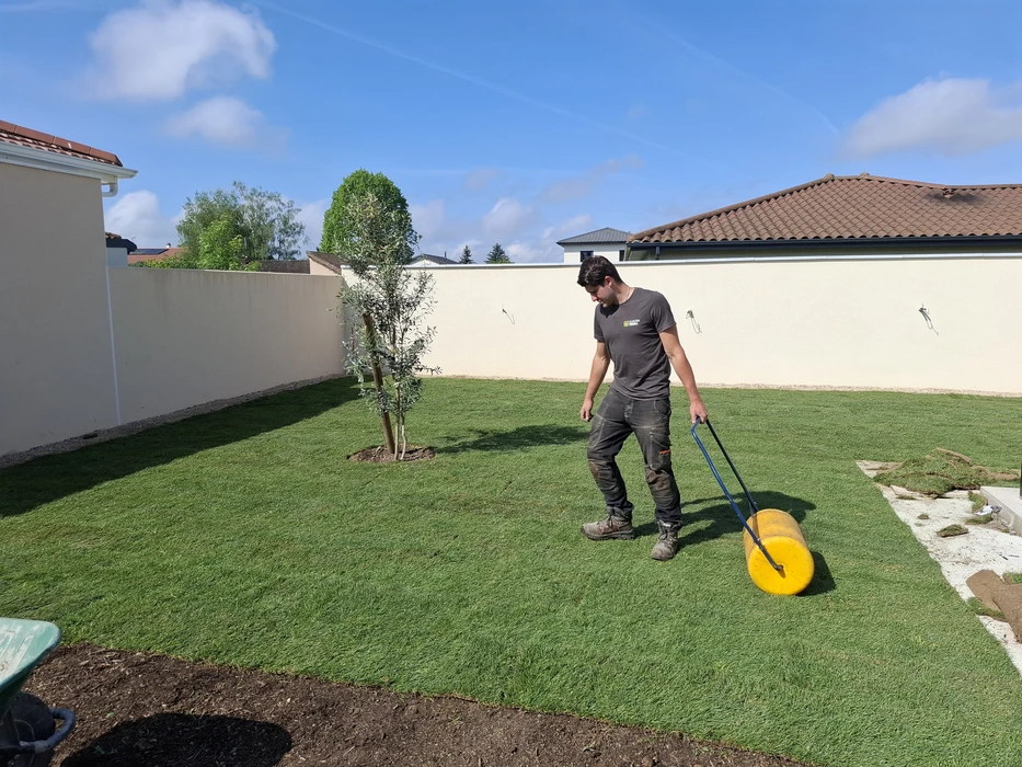 Clôture en bois horizontale récemment installée, séparant une allée goudronnée d'une propriété voisine